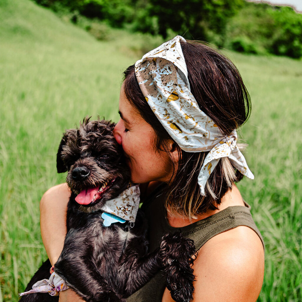 dog pet and its human wearing a matchi bandana dyed with cempasuchil petals and with a printed map of the colima volcano. Matchi & Company: Live and Let it Flow Collection