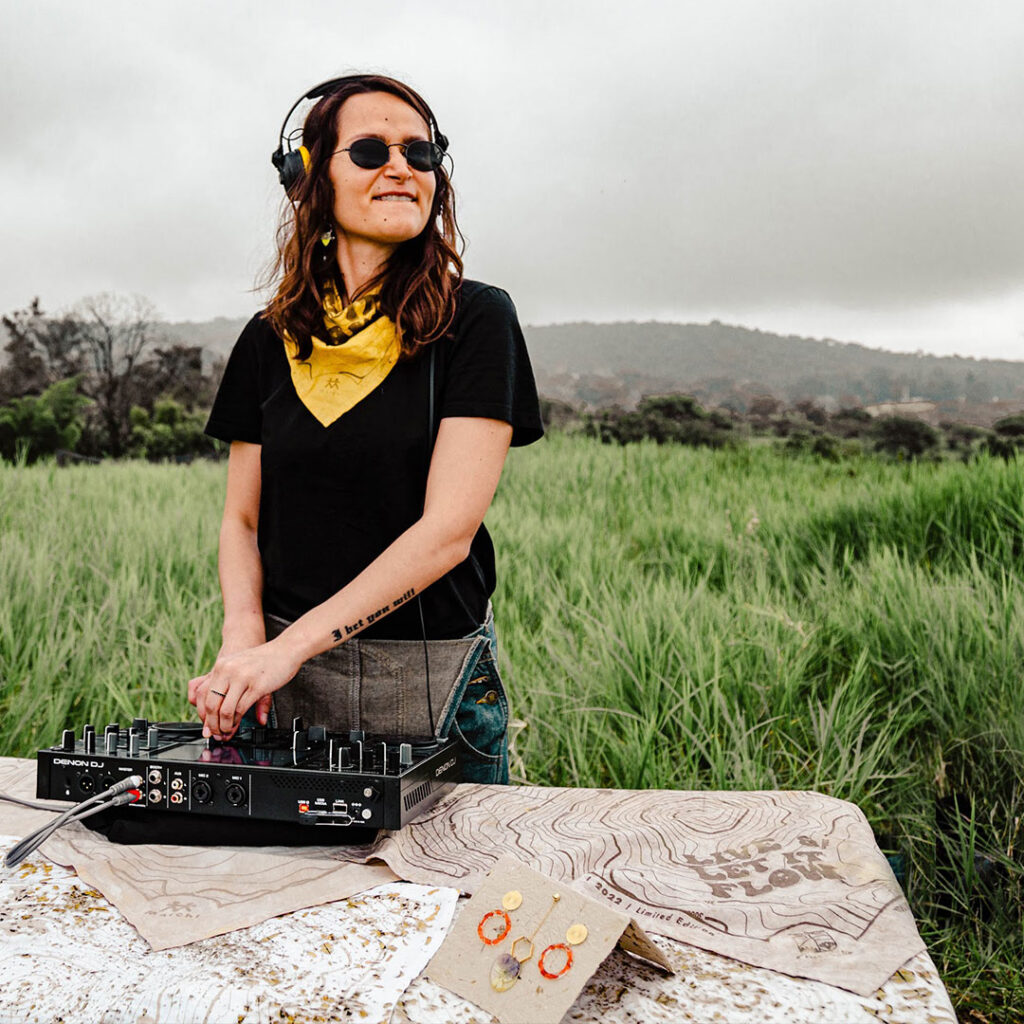 Viri Merino music curator  from Lacaie Band playing music outdoors in Make Make huerto Organico near to colima volcano, she is wearing a matchi bandana dyed with cempasuchil petals and with a printed map of the colima volcano. Matchi & Company: Live and Let it Flow Collection