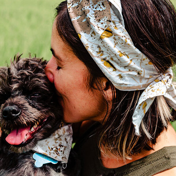 dog pet and its human wearing a matchi bandana dyed with cempasuchil petals and with a printed map of the colima volcano. Matchi & Company: Live and Let it Flow Collection